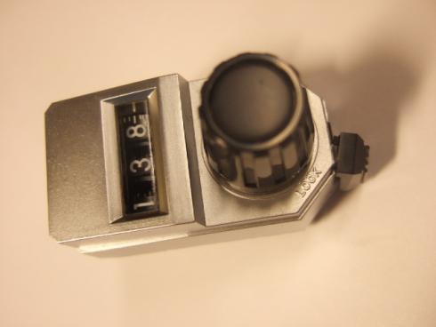 Monikierrosnuppi CONTELEC S45 - 6 mm akselille. Ruuvikiristys kyljessä. Runko-osa n. 44X25X17mm. Nuppiosa n. 15X16mm. Näyttö: 0..999. Lukitusvivulla. Väri: hopea/musta.