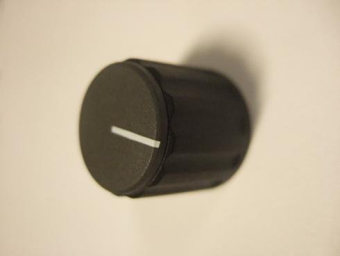 Nuppi 21X19mm - 6mm akselille. Kartiokiinnitys sileille ja uritetuille akseleille. Musta/harmaa lakkiosa/valkoinen osoitinviiva.